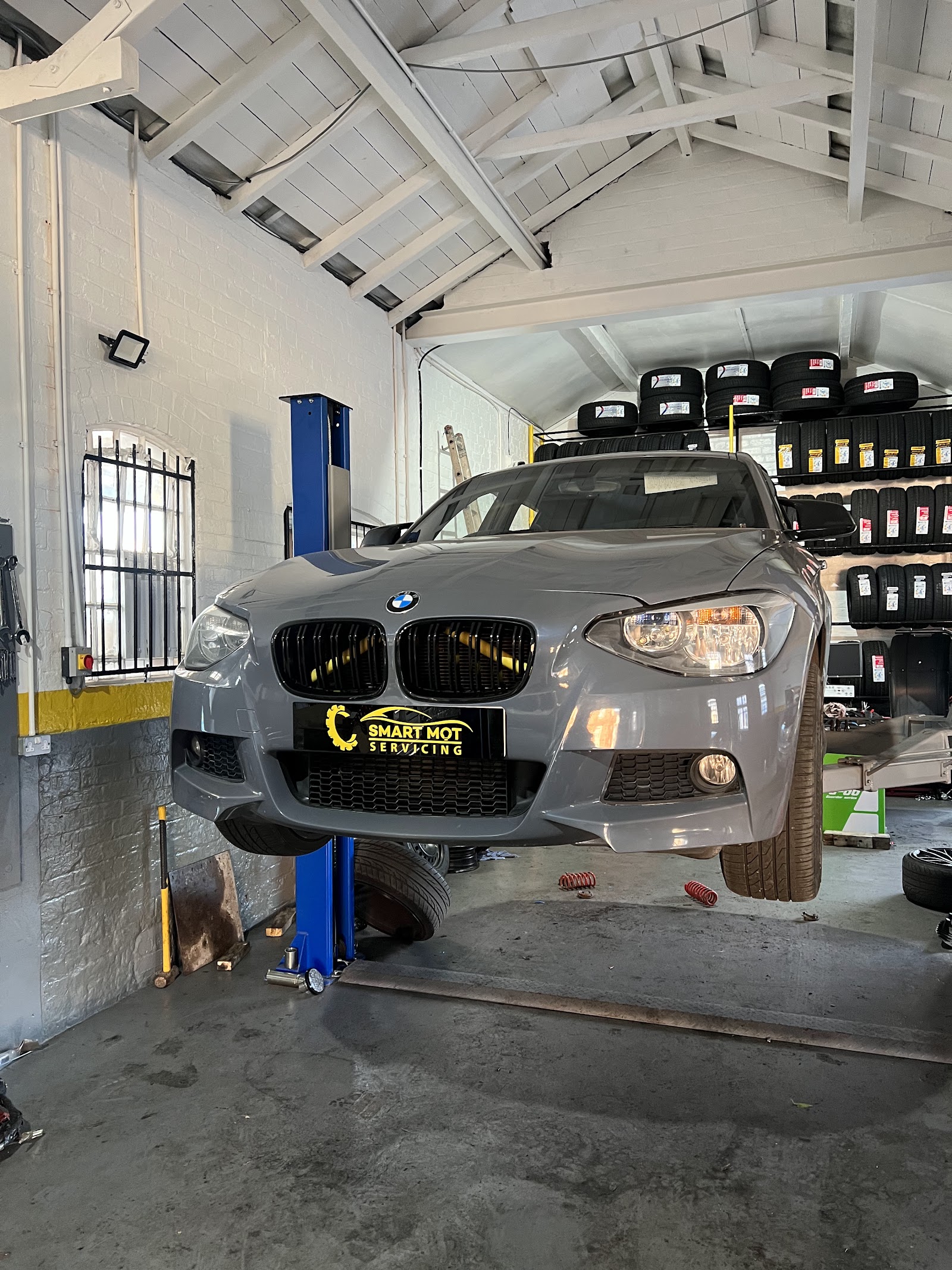A car raised on the two-post ramp mid-service